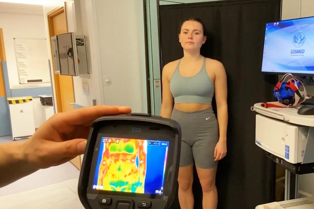 A person holding an infrared image of a woman for a study on how bra size affects sweat rate, conducted by University of Southampton