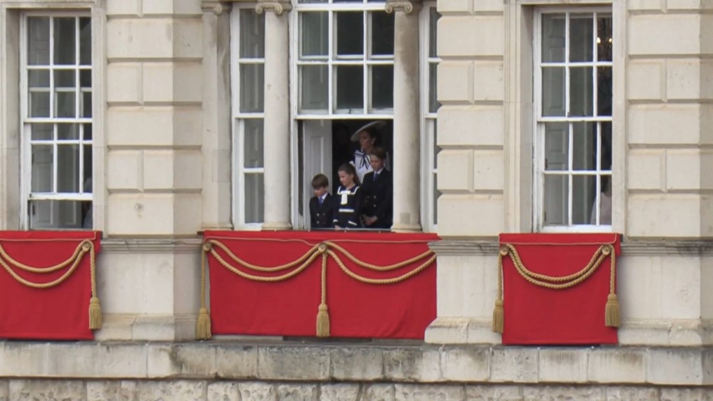 Kate Middleton and her children peak out a window as they look down upon the parade at Horse Guards Parade on June 15, 2024. 