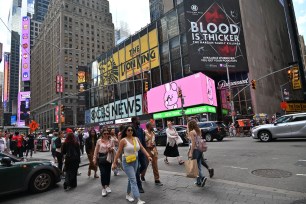 People are walking in Times Square where the machete stabbing is taking place. 