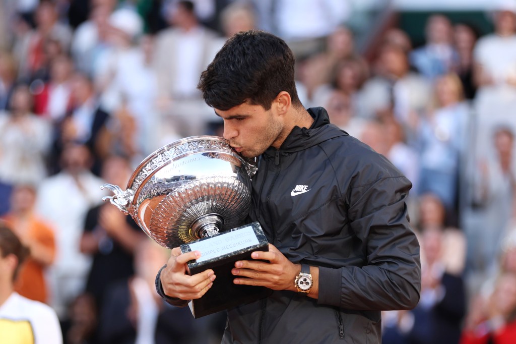 Carlos Alcaraz kisses the trophy after winning the 2024 French Open on Sunday.
