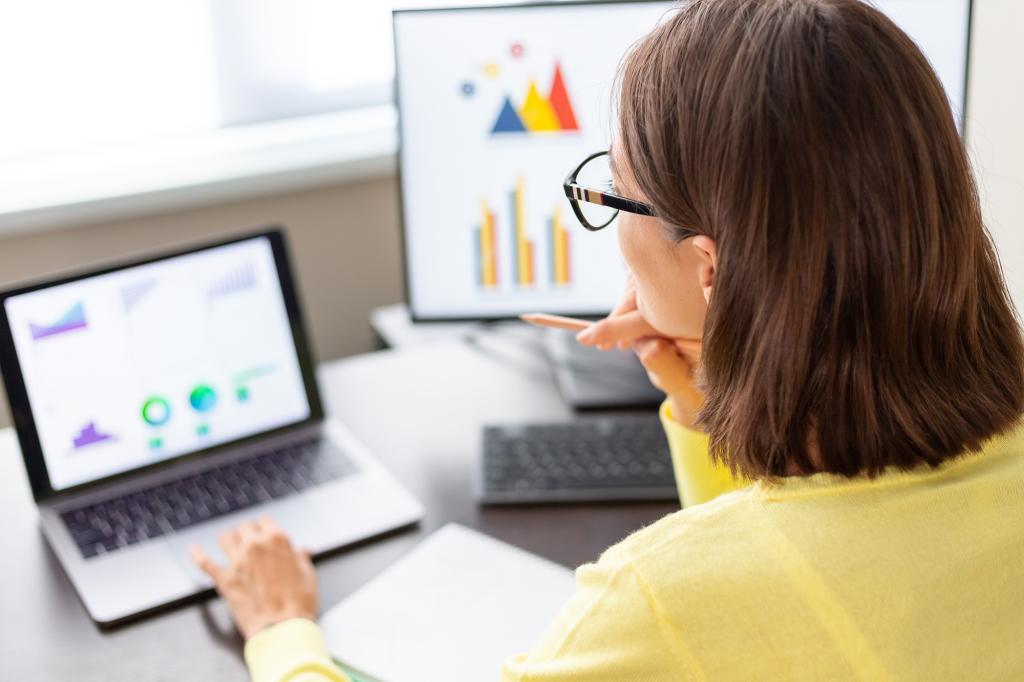 Caucasian businesswoman analyzing financial data on a laptop screen