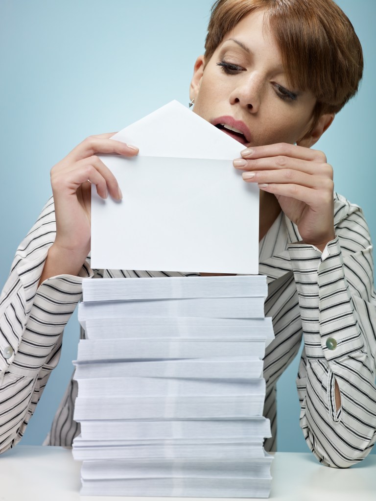 A woman licking an envelope. 