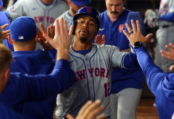 New York Mets shortstop Francisco Lindor celebrating in the dugout after scoring on a single by Pete Alonso during a baseball game