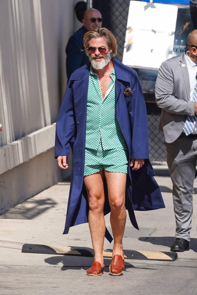 Chris Pine wearing a blue coat and hat, walking down a sidewalk to appear on Jimmy Kimmel Live in Los Angeles, California