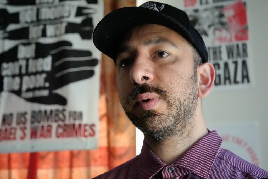 Christopher Hurasay, a protestor, in his bedroom at home on Friday, June 21, 2024 in Hayward, wearing a hat.