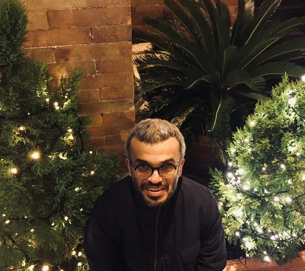 Claudio Gaetani standing near Christmas trees.