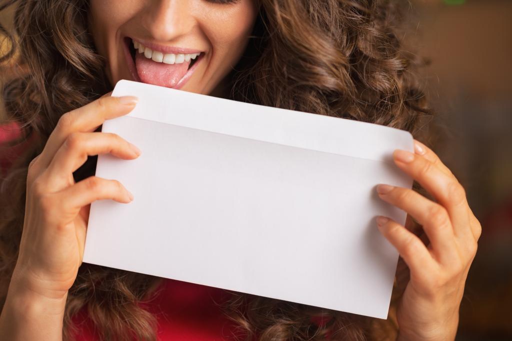 Woman licking an envelope .