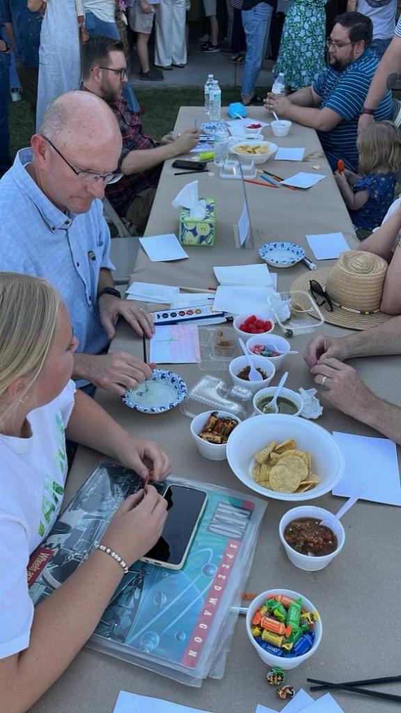 A large gathering of people at Brandon Young's celebration of life event, featuring a bouncy castle and his favorite food