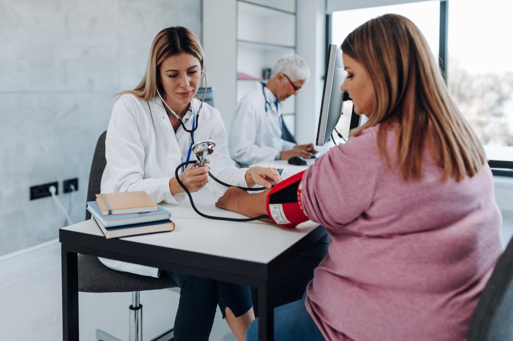 Doctor cardiologist measuring blood pressure of her diabetic patient. Healthcare concept.