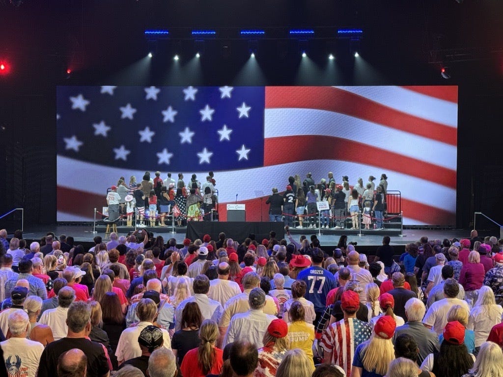 Donald Trump supporters stand for the national anthem ahead of the former president's town hall at Dream City Church in Phoenix on June 6, 2024.