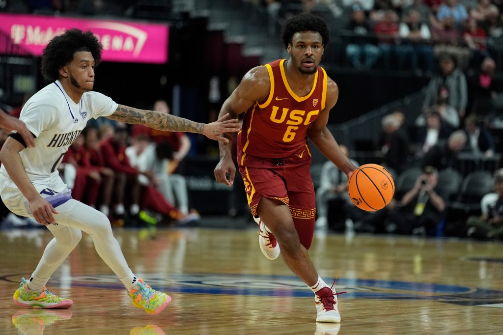 Southern California's Bronny James (6) drives against Washington's Koren Johnson (0) during the first half of an NCAA college basketball game in the first round of the Pac-12 tournament Wednesday, March 13, 2024, in Las Vegas.