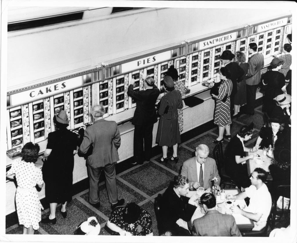 Horn & Hardart customers hit the vending area as others settle for lunch at nearby tables in a scene from around 1940.