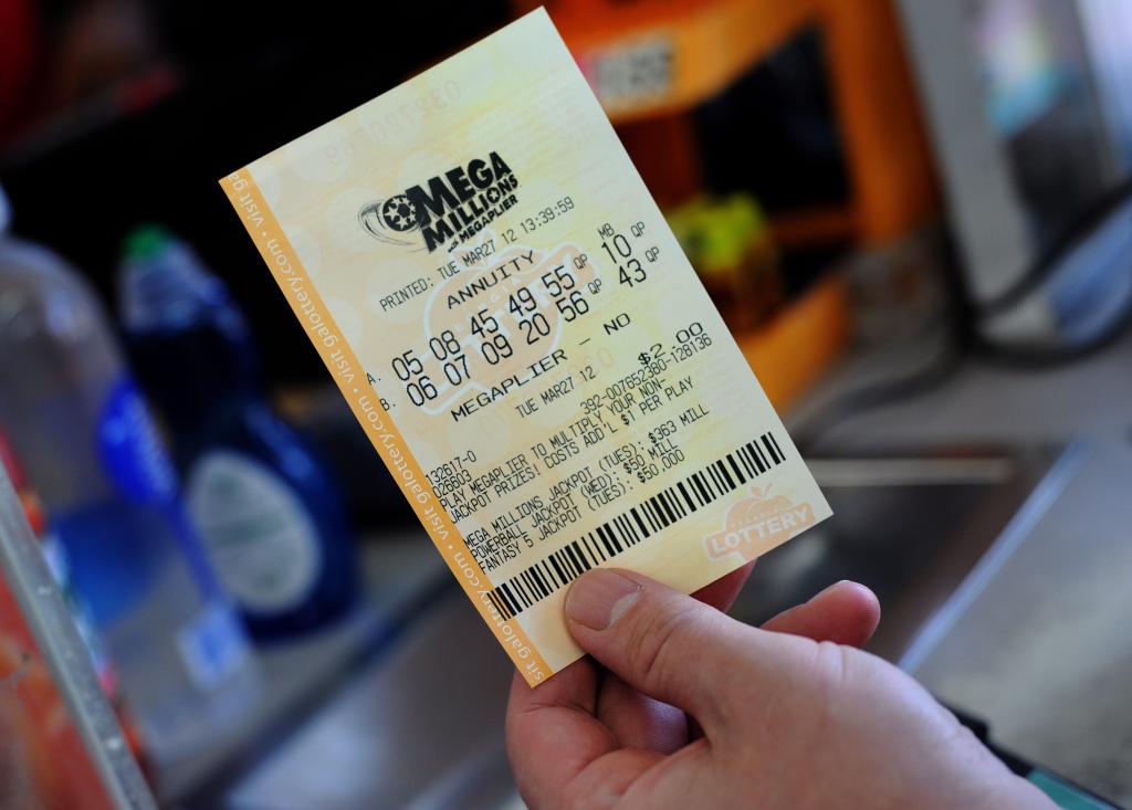 A hopeful Mega Millions multi-state lottery player holds up his ticket after purchasing it at a convenience store in Decatur, Georgia, USA on 27 March 2012.