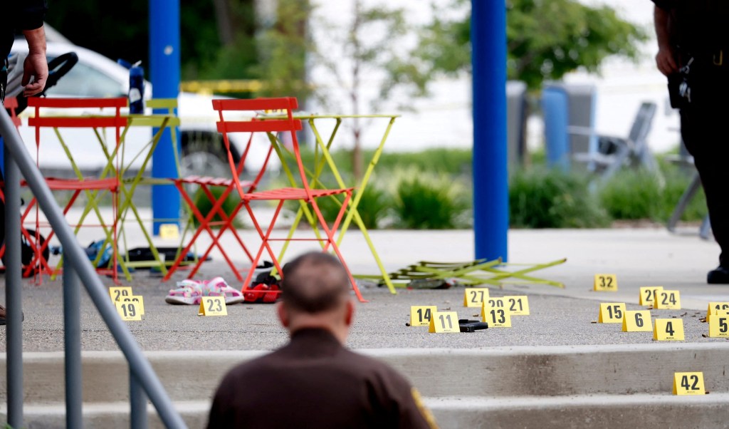 Evidence markers indicate the position of spent shell casings following a mass shooting at the Brooklands Plaza Splash Pad.
