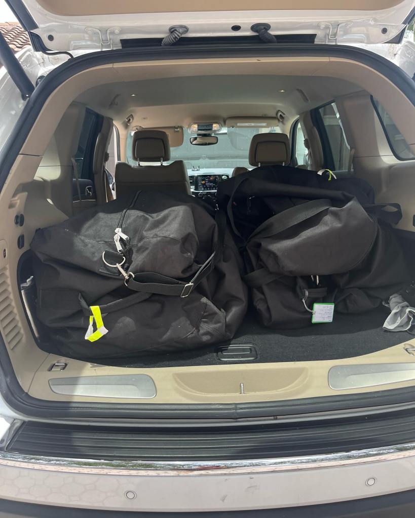 Luggage in the back of a car from First Class Laundry Services, offers packing service for parents sending kids to camp