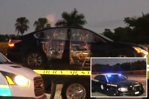 Police car on a tow truck presumably at the scene of a shooting on the Florida Turnpike