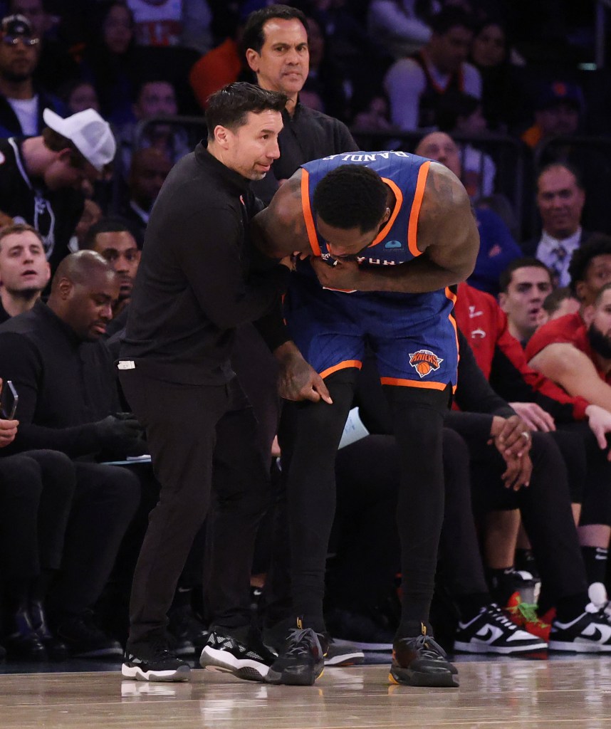 Julius Randle (30) is helped by a trainer after he goes up for a shot and falls over Miami Heat guard Jaime Jaquez Jr. (11) landing on his arm.