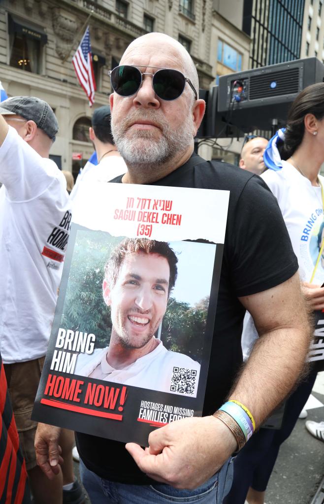 Jonathan Dekel-Chen holding a sign of his son, Sagui Dekel-Chen, at the Israel Day on Fifth parade advocating for the return of hostages