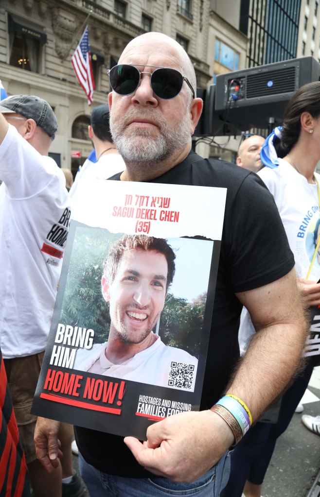 Jonathan Dekel-Chen holding a sign of his son, Sagui Dekel-Chen, at the Israel Day on Fifth parade advocating for the return of hostages