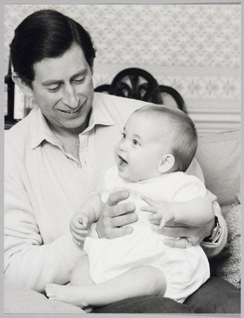 Prince Charles holding his eldest son as a baby in a throwback photo