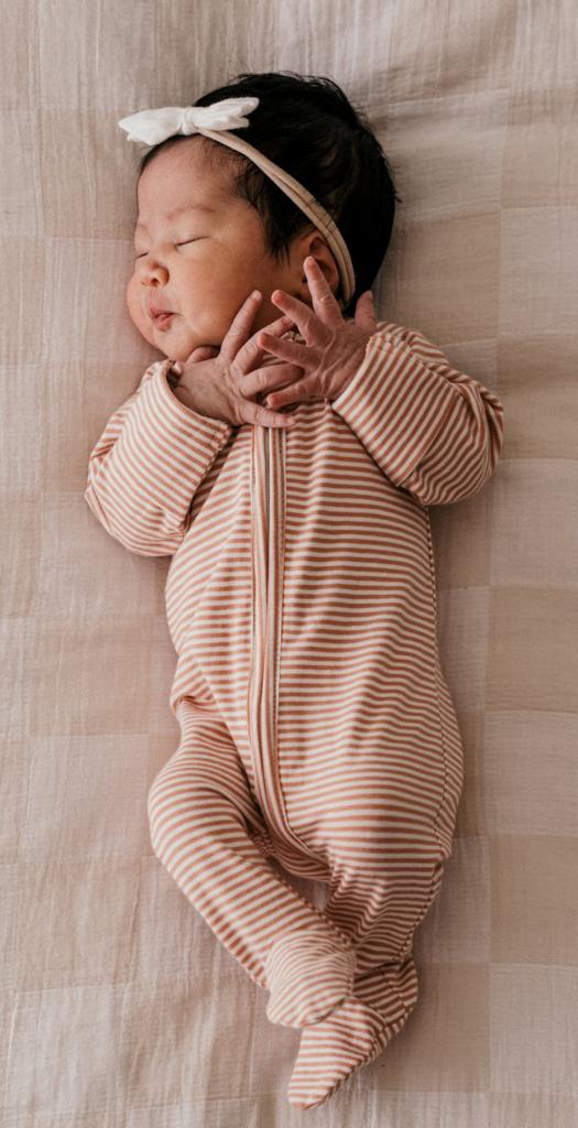 Baby girl of Jenn Gutierrez lying on a bed, born after her mother attended a Taylor Swift concert while in labor