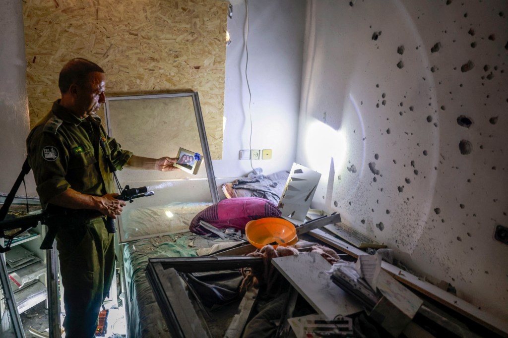 An IDF officer inspects a home in northern Israel that was hit by a Hezbollah rocket on Sunday.