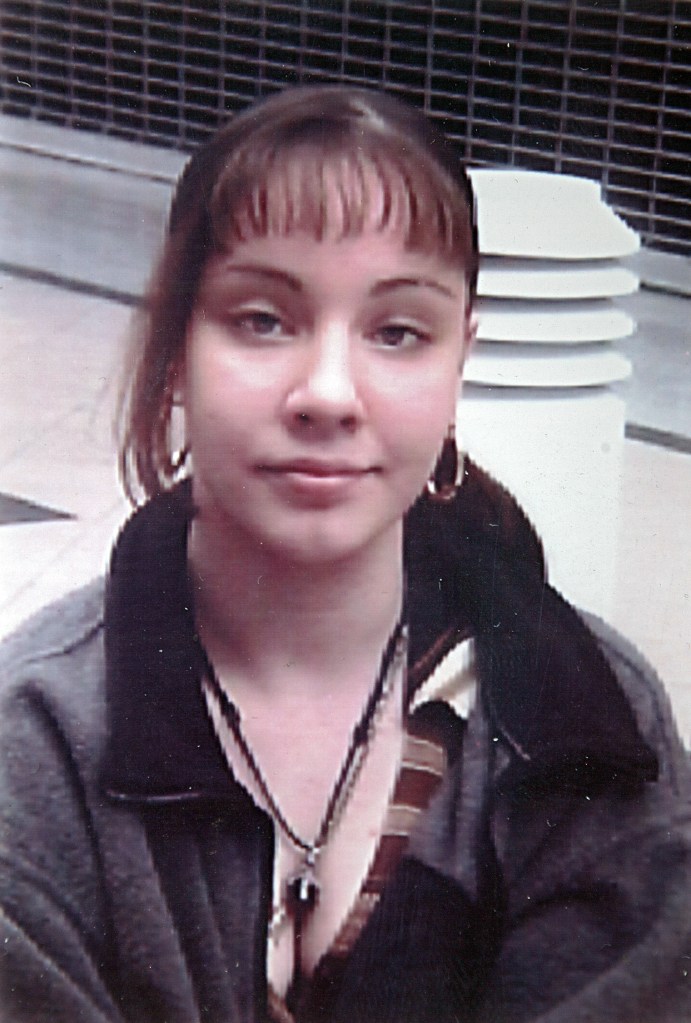 Portrait of Jessica Taylor wearing earrings and a necklace.