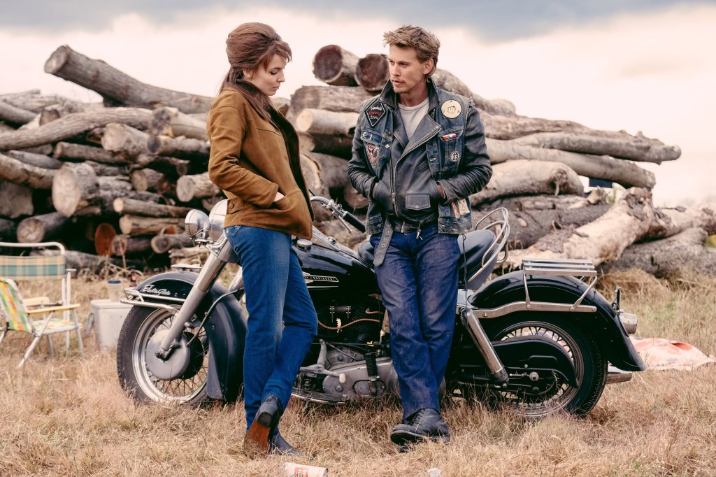 Jodie Comer ad Austin Butler standing by a motorcycle.
