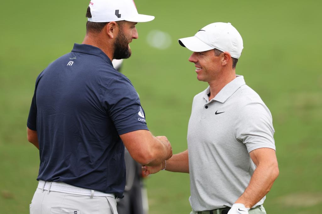 Jon Rahm of Spain and Rory McIlroy of Northern Ireland hug in the practice area prior to the 2024 Masters Tournament at Augusta National Golf Club on April 09, 2024 in Augusta, Georgia.