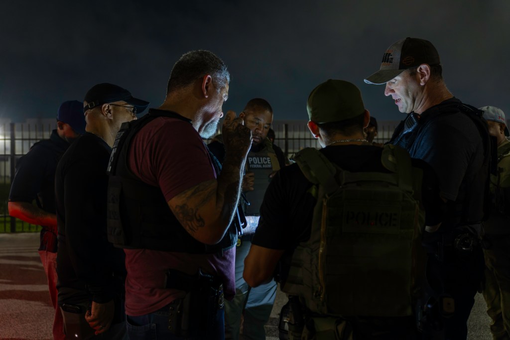 ICE officers gather before an early morning raid in Houston, Texas.