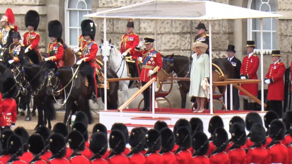 King Charles salutes as Camilla stands nearby while troops march past them on June 15, 2024.