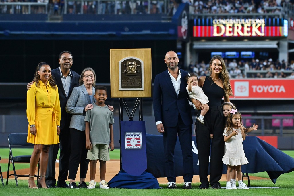 Derek Jeter along side his wife Hannah, and daughters Story, Bella and River and (left side) his father Sanderson, mother Dorothy, sister Sharlee, and nephew Jalen all pose for a photo during a tribute ceremony to mark Jeter's Hall of fame Induction before the Yankees-Rays game on Sept. 9, 2022, at Yankee Stadium in Bronx.  
