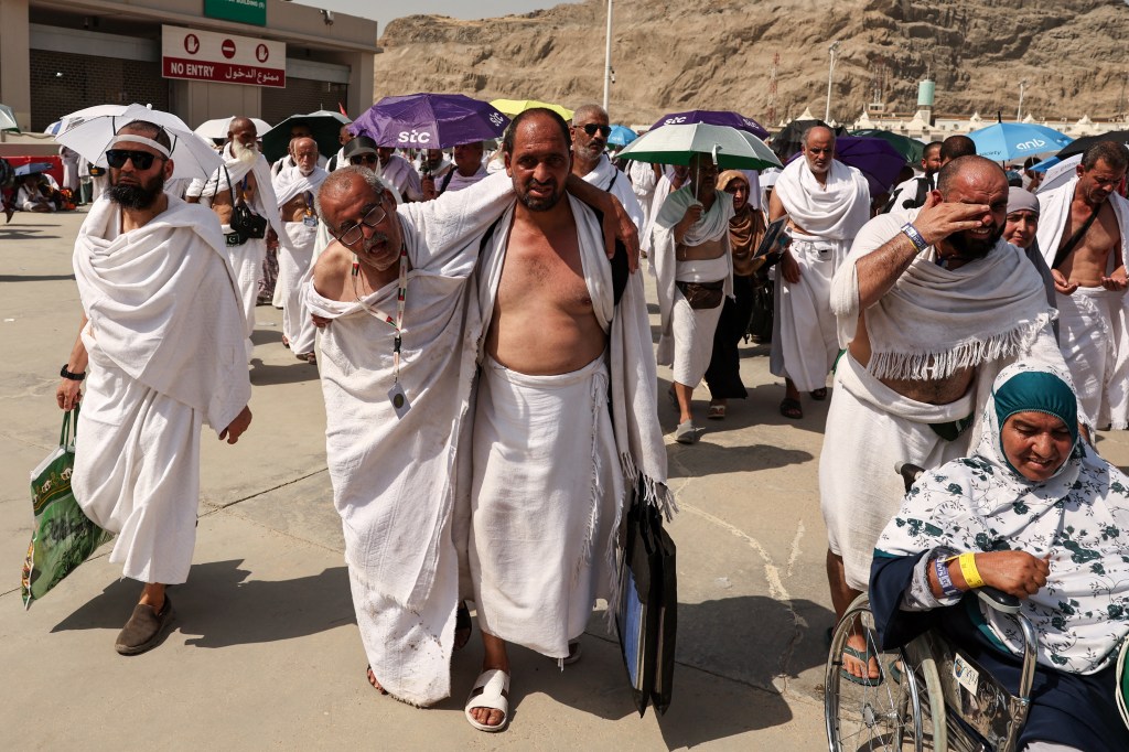 A man effected by the scorching heat is helped by another as Muslim pilgrims trekked during the hajj. 