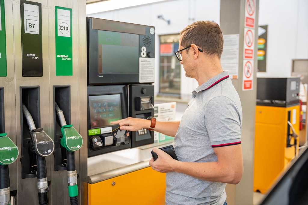 Man paying for gas using a credit card at a self-service pump in Europe