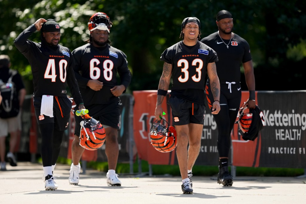 Members of the Cincinnati Bengals in football uniforms walking to the practice field during an OTA offseason workout