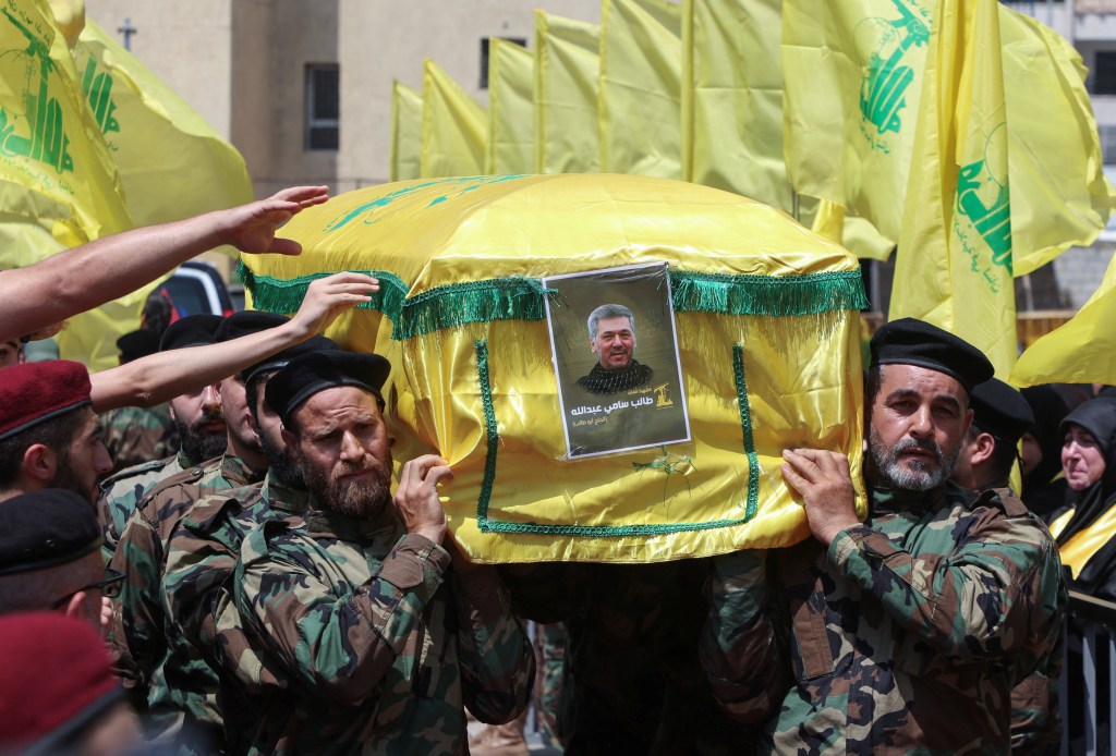 Hezbollah members carrying the coffin of Taleb Abdallah during his funeral in Beirut's southern suburbs