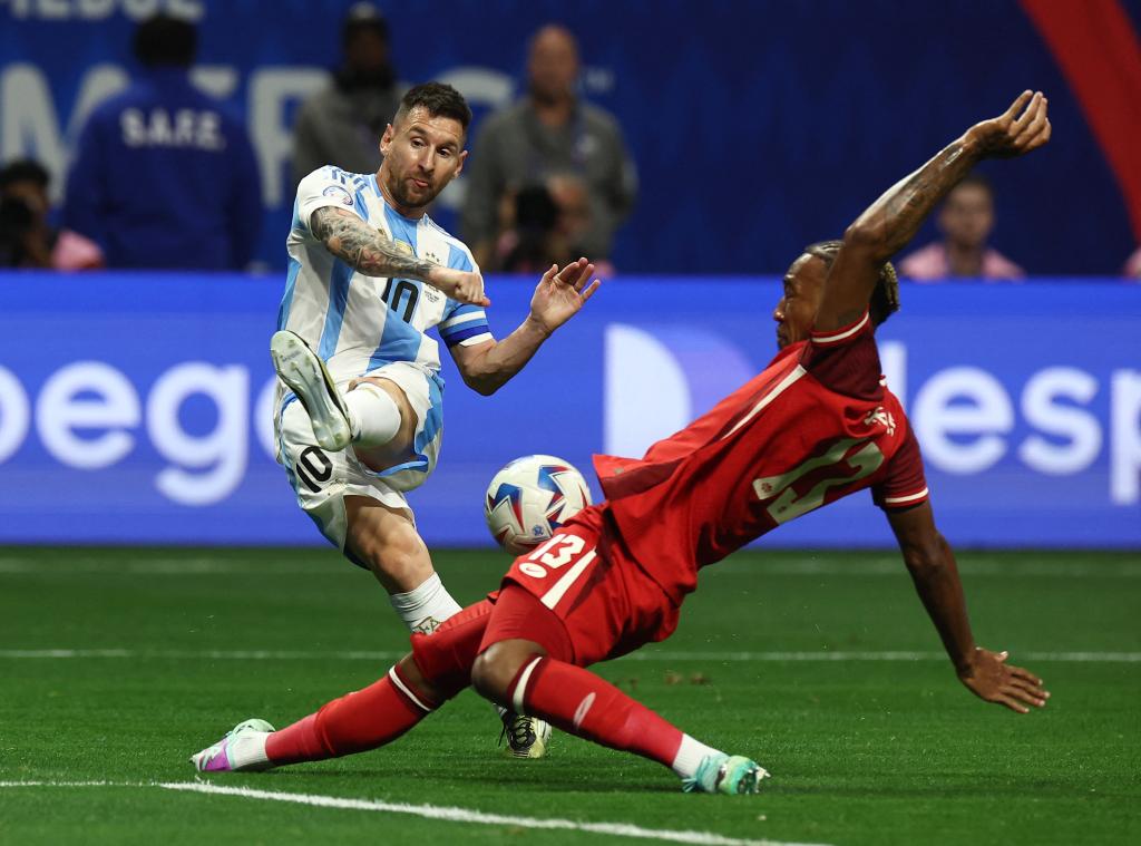 Lionel Messi in blue and white uniform shooting at goal during Copa America 2024, Argentina v Canada match at Mercedes-Benz Stadium, Atlanta, Georgia.