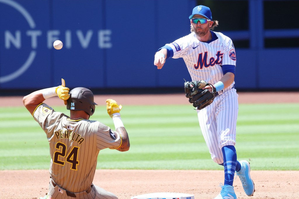 Jeff McNeil attempts to turn a double play during Sunday's game against the Padres.