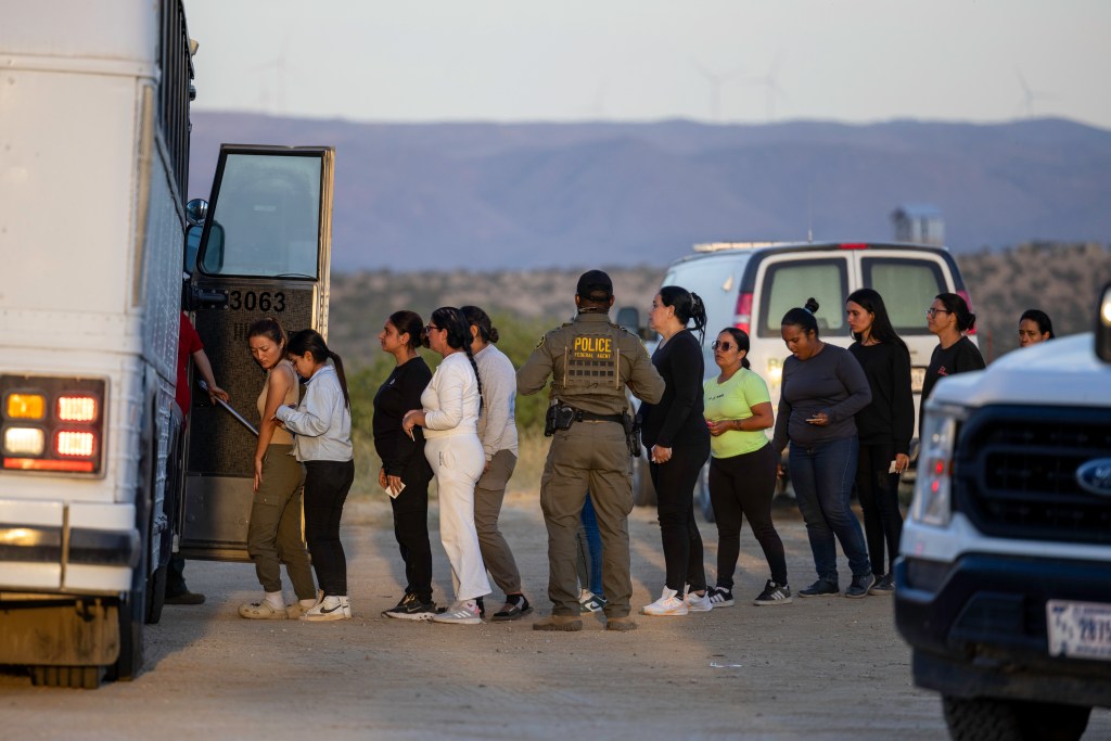 Migrants getting on a bus. 