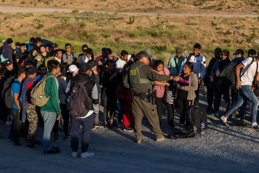 Migrants await processing by Border Patrol after walking around the border fence near Jacumba Hot Springs in California.