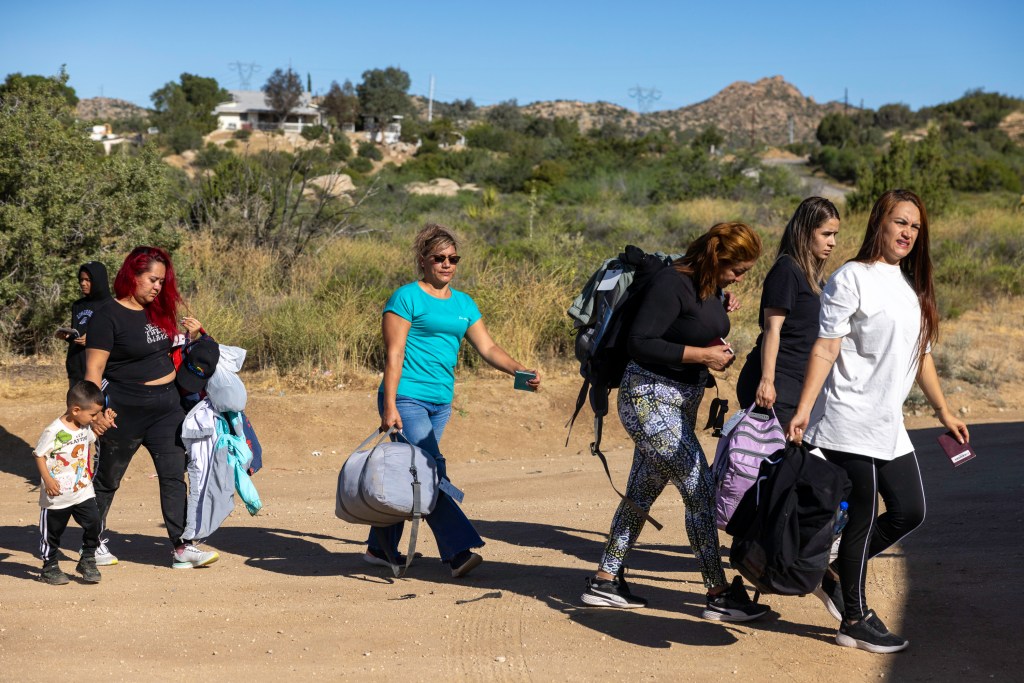 A group of migrant women carry luggage after crossing the southern border into Jacumba, California as border agents take them into custody.