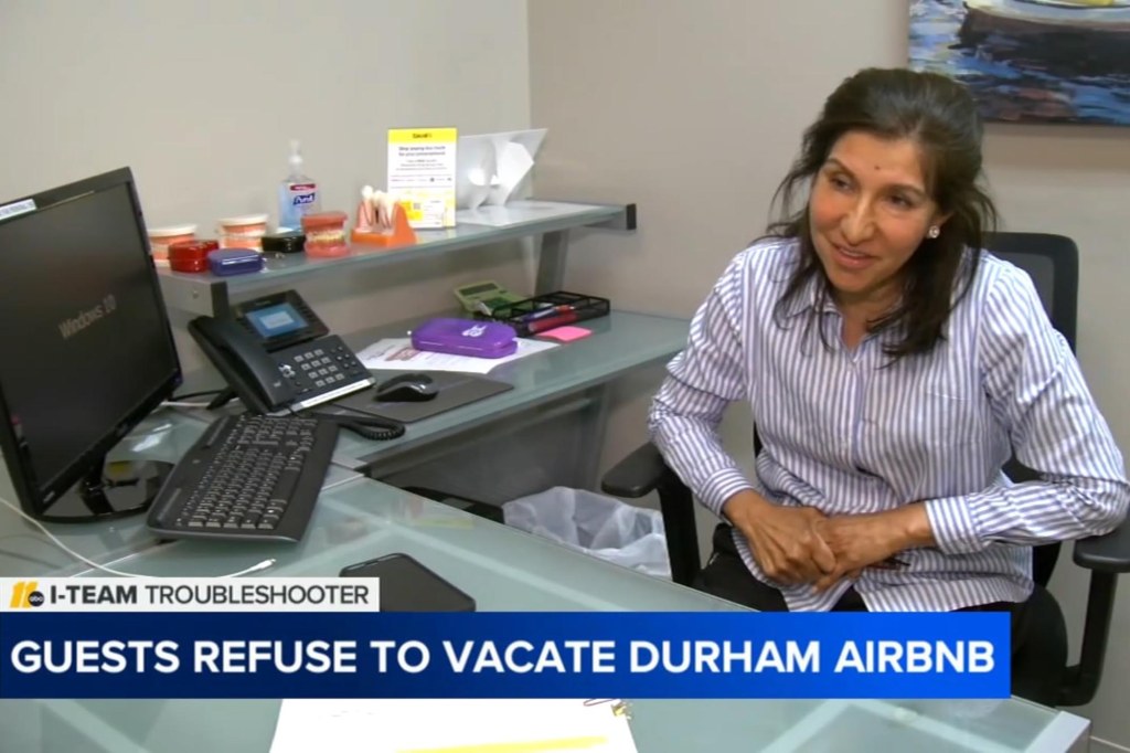 Single mom Farzana Rahman sitting at a desk, distressed over Airbnb guests refusing to leave her rental property in Durham, North Carolina