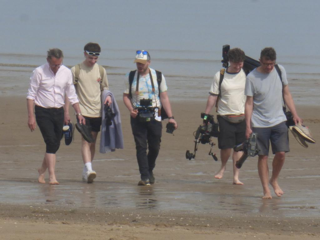 TV presenter Michael Mosley with wife Clare, two women and a camera crew at Colwyn Bay beach, North Wales, weeks before his disappearance