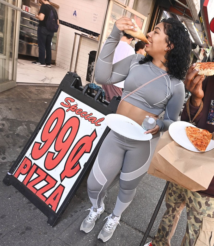 Asanys Payana, 20,  bites into her pizza at the 99 Cents Pizza shop on East 14th Street.