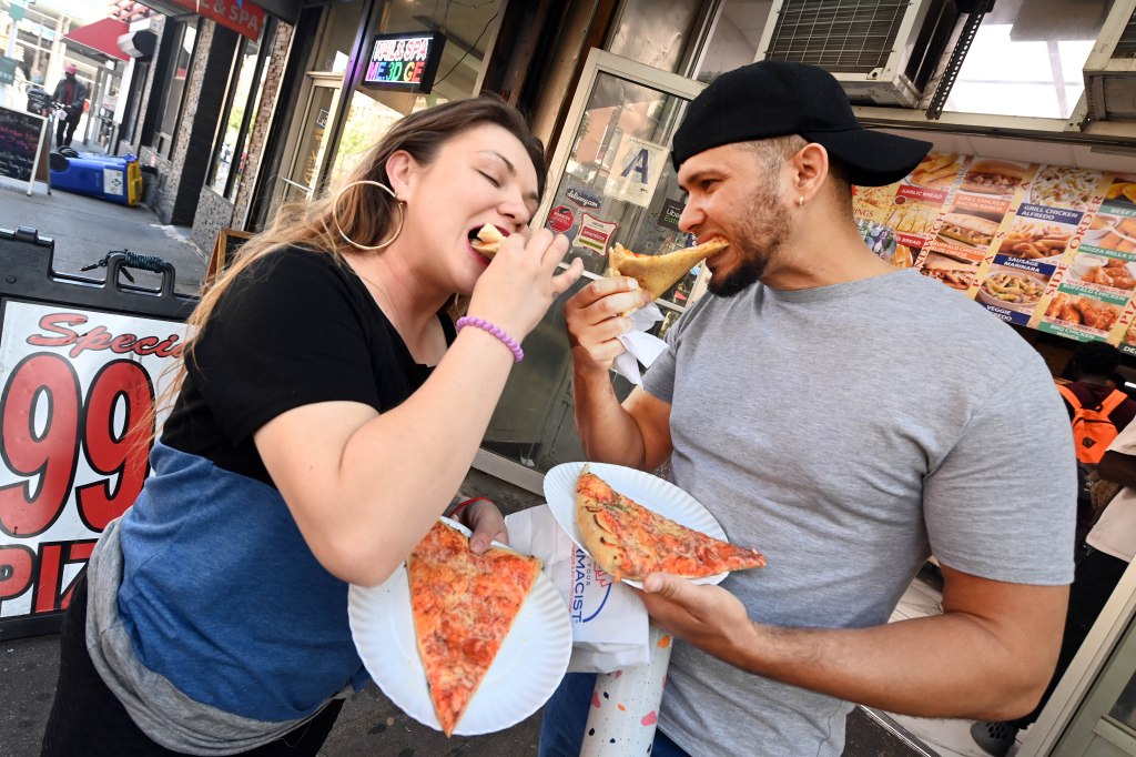 Faustyna Karaban, 33, and boyfriend, Joel Diaz, 37, eat their pizza at the 99 Cents Pizza store on East 14th Street.