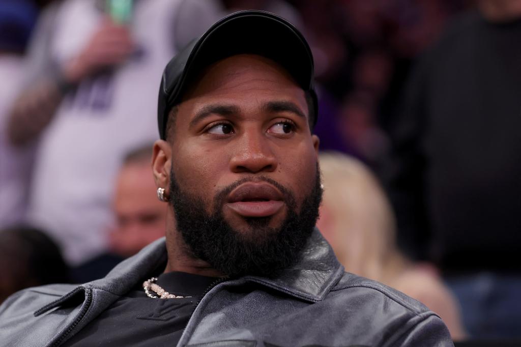 New York Jets linebacker Haason Reddick sitting court side at a basketball game between the New York Knicks and Sacramento Kings