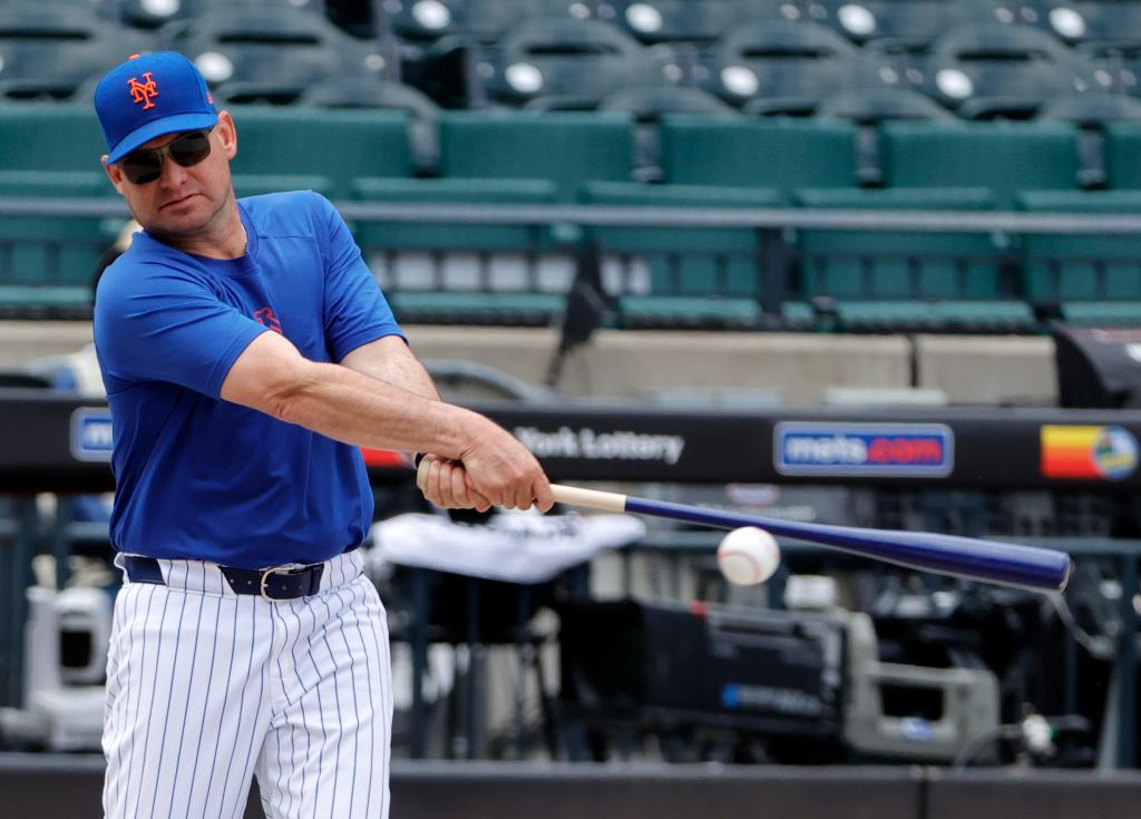 New York Mets manager Carlos Mendoza hitting a ball with a bat during warm ups at Citi Field