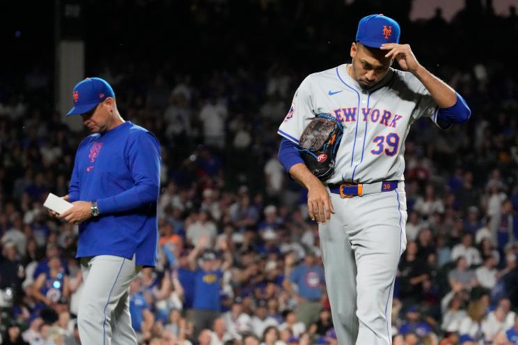 New York Mets relief pitcher Edwin Díaz walks off with manager Carlos Mendoza after being ejected against the Cubs.