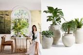 A woman sitting at a table surrounded by potted plants