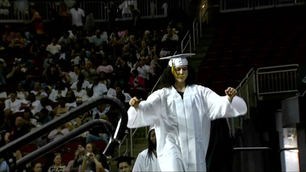 Paramus Catholic High School graduate walking on stage to receive her diploma. 